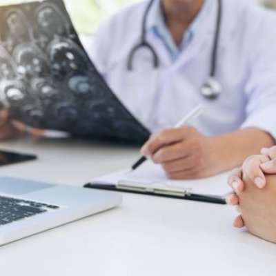 A doctor looks over notes with a pen in hand